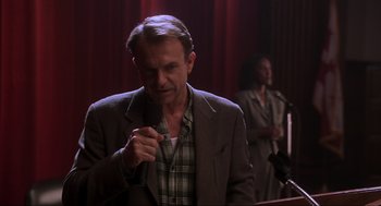 Movie still from “Jurassic Park III” (2001), directed by Joe Johnston – A man standing in front of a microphone in front of a woman; Medium shot, Low angle