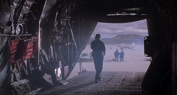Movie still from “Jurassic Park III” (2001), directed by Joe Johnston – A man walking on the ground near an airplane; Wide shot, Over the shoulder angle