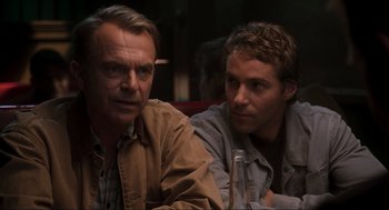 Movie still from “Jurassic Park III” (2001), directed by Joe Johnston – Two men sitting next to each other on a couch; Close Up shot, Over the shoulder angle