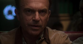 Movie still from “Jurassic Park III” (2001), directed by Joe Johnston – A person wearing a brown jacket; Close Up shot, Over the shoulder angle