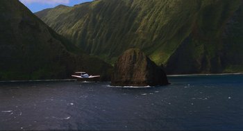 Movie still from “Jurassic Park III” (2001), directed by Joe Johnston – An airplane flying over a body of water near mountains; Extreme Wide shot, High angle