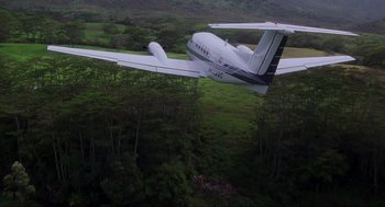 Movie still from “Jurassic Park III” (2001), directed by Joe Johnston – An airplane is flying over a lush green field; Extreme Wide shot, Overhead angle