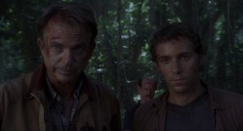 Movie still from “Jurassic Park III” (2001), directed by Joe Johnston – A couple of men standing next to each other in the woods; Close Up shot, Over the shoulder angle