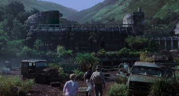 Movie still from “Jurassic Park III” (2001), directed by Joe Johnston – A group of people standing in front of an abandoned building; Extreme Wide shot, Low angle