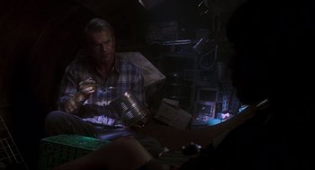 Movie still from “Jurassic Park III” (2001), directed by Joe Johnston – A man sitting at a table holding a glass of wine; Medium shot, High angle