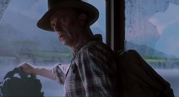 Movie still from “Jurassic Park III” (2001), directed by Joe Johnston – A man in a hat and plaid shirt looking out of a window; Close Up shot, Low angle
