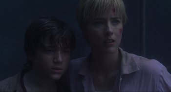 Movie still from “Jurassic Park III” (2001), directed by Joe Johnston – Two young people standing next to each other in a dark room; Close Up shot, Low angle