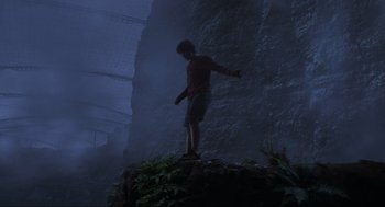 Movie still from “Jurassic Park III” (2001), directed by Joe Johnston – A man standing on top of a rock in the middle of the night; Wide shot, Low angle