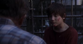 Movie still from “Jurassic Park III” (2001), directed by Joe Johnston – A young boy with a red shirt and a red bandage on his face; Close Up shot, Over the shoulder angle