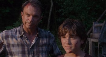 Movie still from “Jurassic Park III” (2001), directed by Joe Johnston – A man standing next to a young boy with blood all over his face; Close Up shot, Low angle