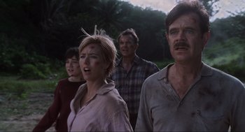 Movie still from “Jurassic Park III” (2001), directed by Joe Johnston – A group of people standing next to each other in a field; Medium shot, Low angle