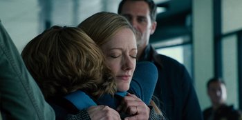 Movie still from “Jurassic World” (2015), directed by Colin Trevorrow – A woman is hugging a man while another man looks on; Close Up shot, Over the shoulder angle
