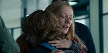 Movie still from “Jurassic World” (2015), directed by Colin Trevorrow – A woman is hugging a boy while they both look at each other; Close Up shot, Over the shoulder angle