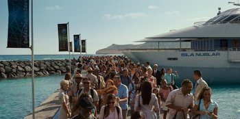 Movie still from “Jurassic World” (2015), directed by Colin Trevorrow – A crowd of people walking on a pier next to a boat; Extreme Wide shot, High angle