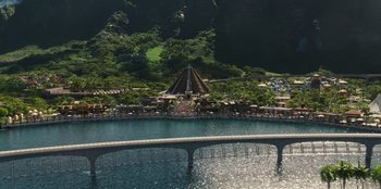Movie still from “Jurassic World” (2015), directed by Colin Trevorrow – An aerial view of a lake with a bridge in the foreground; Extreme Wide shot, High angle