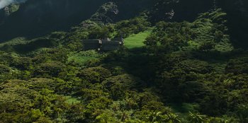 Movie still from “Jurassic World” (2015), directed by Colin Trevorrow – A house sitting on top of a lush green hillside; Extreme Wide shot, High angle