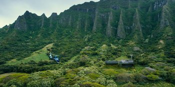 Movie still from “Jurassic World” (2015), directed by Colin Trevorrow – A helicopter flying over a lush green hillside; Extreme Wide shot, High angle