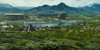 Movie still from “Jurassic World” (2015), directed by Colin Trevorrow – An aerial view of a tropical resort with a mountain in the background; Extreme Wide shot, High angle