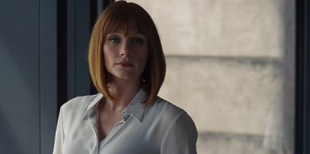 Movie still from “Jurassic World” (2015), directed by Colin Trevorrow – A woman in a white shirt is standing in front of a window; Close Up shot, Over the shoulder angle
