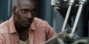 Movie still from “Jurassic World” (2015), directed by Colin Trevorrow – A man in a red shirt is looking at the camera; Close Up shot, High angle