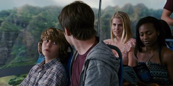 Movie still from “Jurassic World” (2015), directed by Colin Trevorrow – A group of young people riding on the back of a bus; Medium shot, Over the shoulder angle