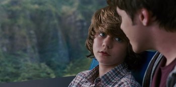 Movie still from “Jurassic World” (2015), directed by Colin Trevorrow – A young boy sitting in a car with his hand on his head; Close Up shot, Over the shoulder angle