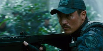 Movie still from “Jurassic World” (2015), directed by Colin Trevorrow – A person holding a gun; Close Up shot, Over the shoulder angle