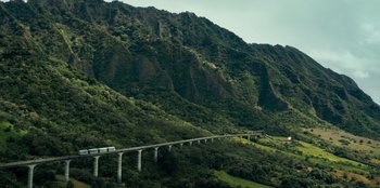 Movie still from “Jurassic World” (2015), directed by Colin Trevorrow – A train traveling on a bridge over a river; Extreme Wide shot, Low angle