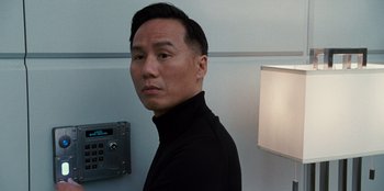 Movie still from “Jurassic World” (2015), directed by Colin Trevorrow – A man in a black shirt is standing in a room; Close Up shot, Low angle