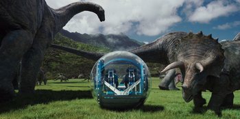 Movie still from “Jurassic World” (2015), directed by Colin Trevorrow – Two dinosaurs are attacking an inflatable ball; Extreme Wide shot, Low angle