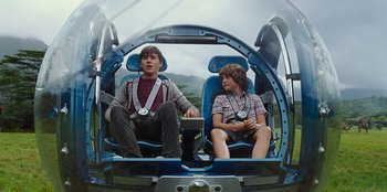 Movie still from “Jurassic World” (2015), directed by Colin Trevorrow – Two young men sitting in a helicopter with a sky background; Medium shot, High angle