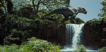 Movie still from “Jurassic World” (2015), directed by Colin Trevorrow – A dinosaur is jumping over a waterfall in a park; Extreme Wide shot, Low angle