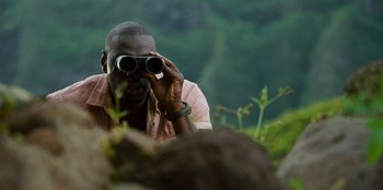 Movie still from “Jurassic World” (2015), directed by Colin Trevorrow – A man looking through a pair of binoculars; Close Up shot, Over the shoulder angle