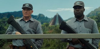 Movie still from “Jurassic World” (2015), directed by Colin Trevorrow – Two men standing next to each other on a bridge; Medium shot, Low angle