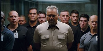 Movie still from “Jurassic World” (2015), directed by Colin Trevorrow – A group of men standing next to each other in front of a mirror; Medium shot, Low angle