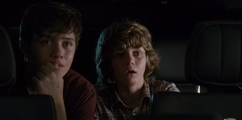 Movie still from “Jurassic World” (2015), directed by Colin Trevorrow – Two young men sitting next to each other in a dark room; Close Up shot, Over the shoulder angle