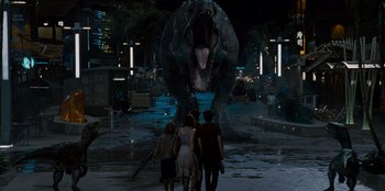 Movie still from “Jurassic World” (2015), directed by Colin Trevorrow – A group of people walking in front of a dinosaur statue; Extreme Wide shot, Over the shoulder angle