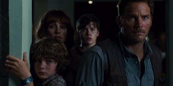 Movie still from “Jurassic World” (2015), directed by Colin Trevorrow – A group of people standing next to each other in a room; Close Up shot, Low angle
