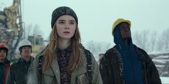 Movie still from “Jurassic World Dominion” (2022), directed by Colin Trevorrow – A young woman in a hat and jacket standing next to a man; Medium shot, Low angle