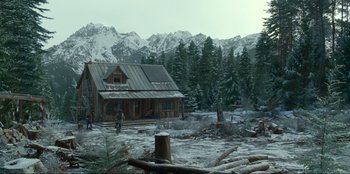 Movie still from “Jurassic World Dominion” (2022), directed by Colin Trevorrow – A log cabin in the middle of a snowy forest; Extreme Wide shot, High angle
