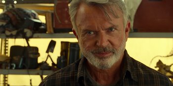 Movie still from “Jurassic World Dominion” (2022), directed by Colin Trevorrow – An older man with grey hair and a gray beard; Close Up shot, Over the shoulder angle