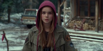 Movie still from “Jurassic World Dominion” (2022), directed by Colin Trevorrow – A young woman wearing a hooded jacket in the snow; Close Up shot, Over the shoulder angle