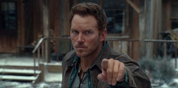 Movie still from “Jurassic World Dominion” (2022), directed by Colin Trevorrow – A man pointing at the camera with a serious look on his face; Close Up shot, Over the shoulder angle
