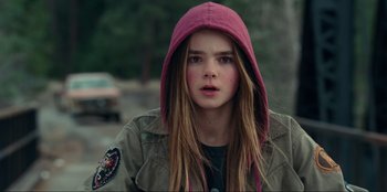 Movie still from “Jurassic World Dominion” (2022), directed by Colin Trevorrow – A young girl with long hair wearing a pink hooded jacket; Close Up shot, High angle