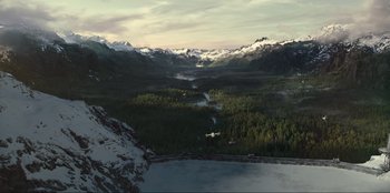 Movie still from “Jurassic World Dominion” (2022), directed by Colin Trevorrow – An airplane flying over a body of water near mountains; Extreme Wide shot, High angle