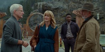 Movie still from “Jurassic World Dominion” (2022), directed by Colin Trevorrow – A group of people standing next to each other on a street; Medium shot, Over the shoulder angle