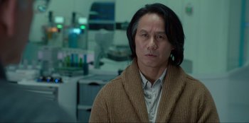 Movie still from “Jurassic World Dominion” (2022), directed by Colin Trevorrow – A man with long black hair wearing a brown sweater; Close Up shot, Low angle