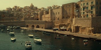 Movie still from “Jurassic World Dominion” (2022), directed by Colin Trevorrow – Boats are parked in the water near a city; Extreme Wide shot, High angle