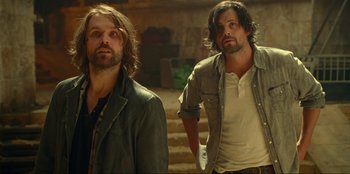 Movie still from “Jurassic World Dominion” (2022), directed by Colin Trevorrow – A couple of men standing next to each other; Medium shot, Low angle