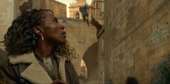 Movie still from “Jurassic World Dominion” (2022), directed by Colin Trevorrow – A woman standing in the middle of an alley way; Medium shot, Low angle